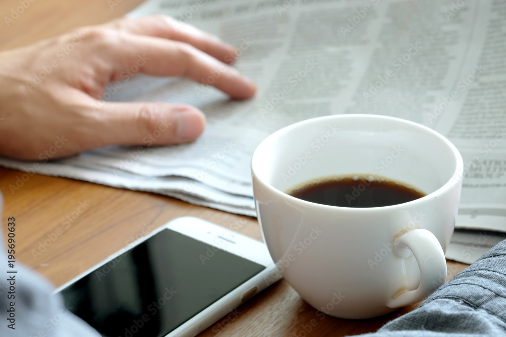 Men read newspapers on the desk with coffee cup and smartphones. Men read newspapers on the desk with coffee cup and smartphones.