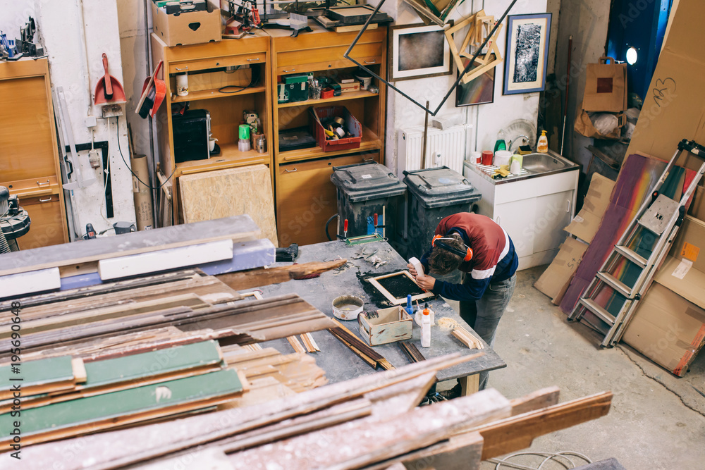 Overhead Shot of Carpenter Applying Wood Glue to Wooden Picture Frame Overhead Shot of Carpenter Applying Wood Glue to Wooden Picture Frame