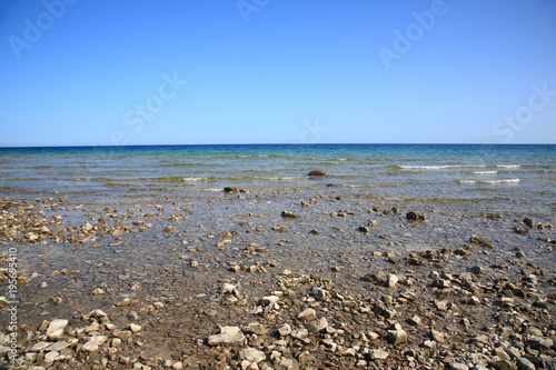 Seashore of Lake Huron - Waves reach rocky shoreline of Great Lake in Michigan