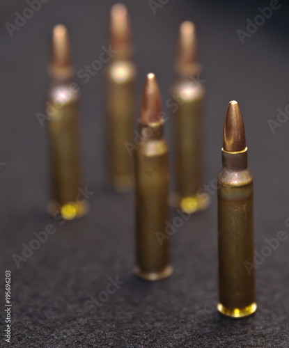 Five .223 rounds on a black background