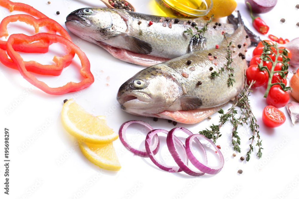 Fish trout with spices and vegetables on a white background