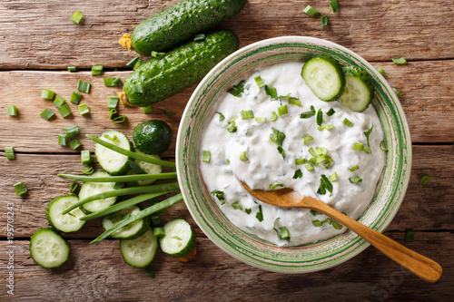 Indian spicy sauce raita with herbs and cucumber close-up in a bowl. horizontal top view
