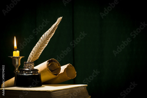 Photo The concept of education and writing, a pen in an inkwell and a candle with a ca