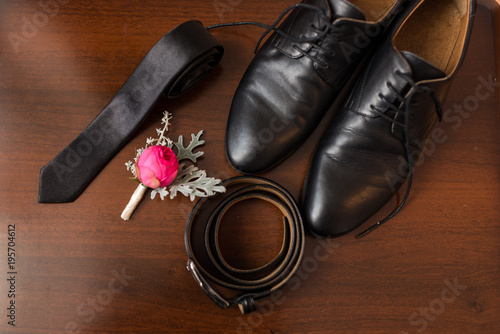 Groom’s accessories: flower boutonniere, leather belt, necktie, shoes. Wedding