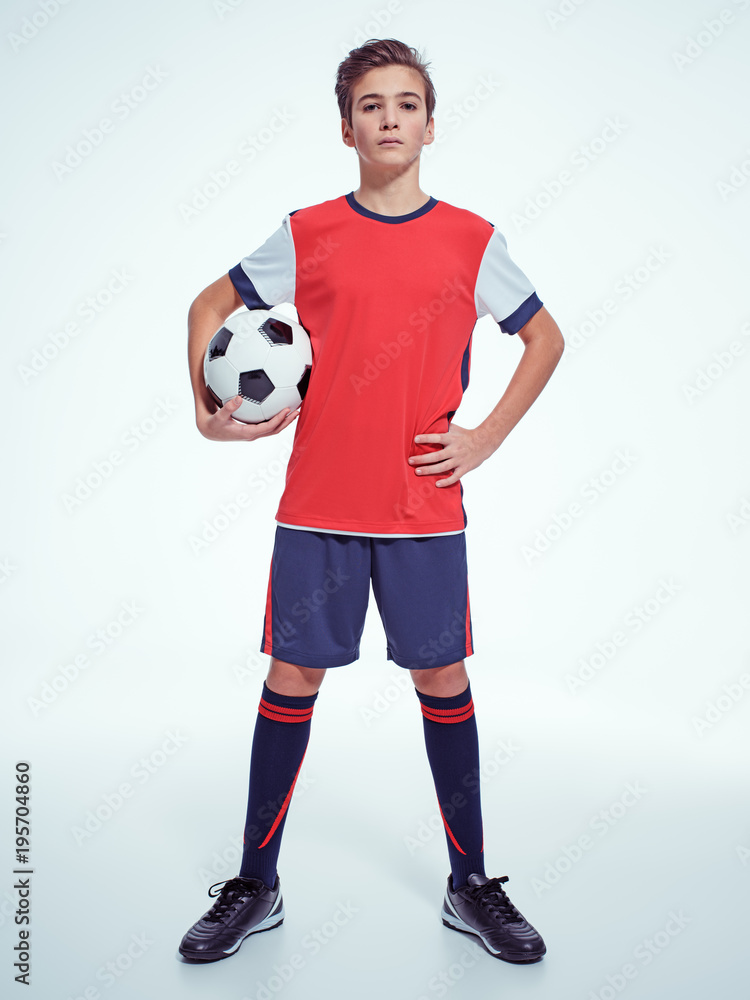 Photo of teen boy in sportswear holding soccer ball