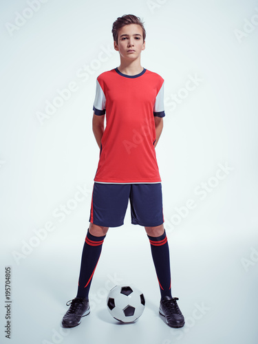 Photo of teen boy in sportswear holding soccer ball