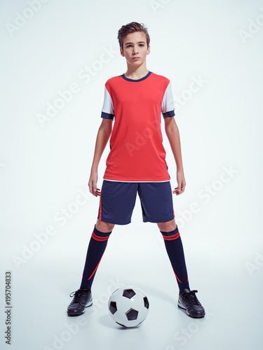 Fototapeta Naklejka Na Ścianę i Meble -  Photo of teen boy in sportswear holding soccer ball