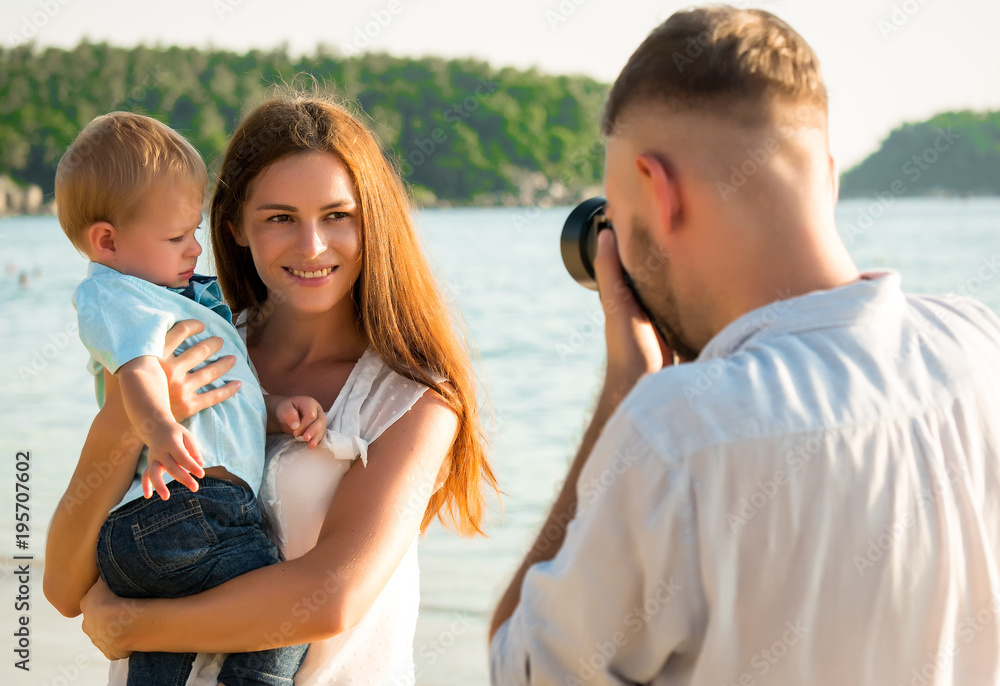 Men are taking pictures of his family  on the beach While relaxing on weekends in travel and holiday concept.