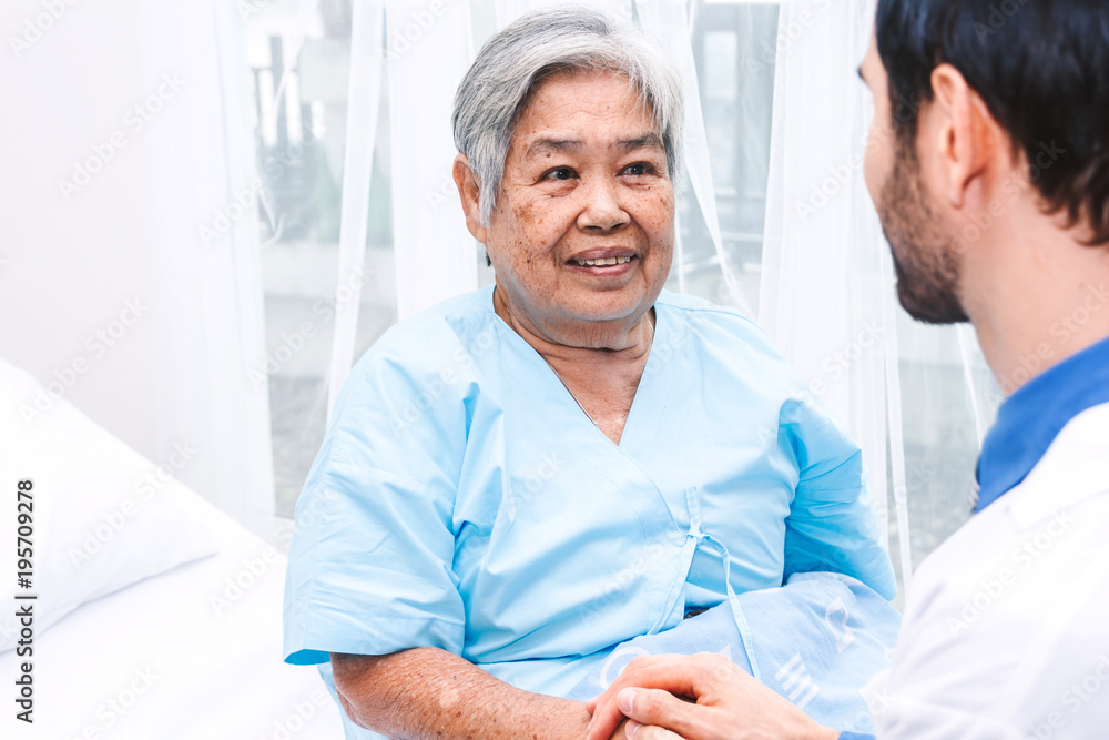 Obraz premium Doctor holding elderly person hand with care in hospital.healthcare and medicine