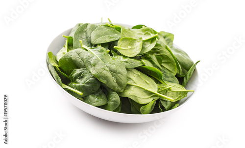 Spinach. Fresh baby spinach leaves in plate isolated on white