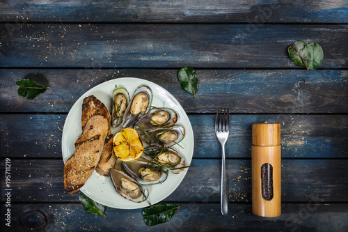 Mussels and bread toasts on on a white plate. Top view photo