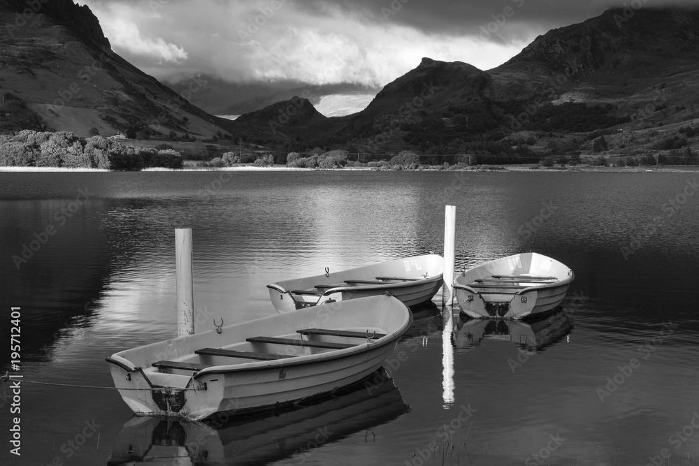 Black and white Landscape image of rowing boats on Llyn Nantlle in Snowdonia at sunset