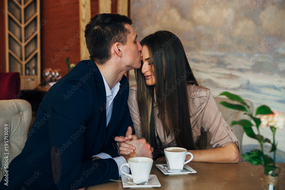 Dating in the cafe. Beautiful young couple sitting in the cafe, drinking coffee Love, dating Dating in the cafe. Beautiful young couple sitting in the cafe, drinking coffee Love, dating