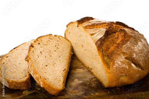 Loaf of rustic german bread on wooden board, isolated on white