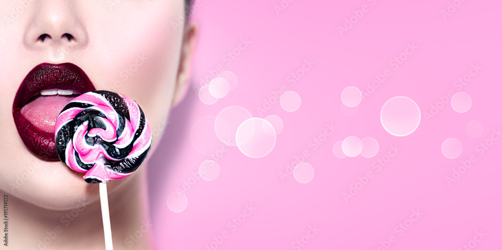 Sexy beauty girl eating lollipop. Glamour model woman licking sweet  colorful lollipop candy over pink background Stock Photo | Adobe Stock