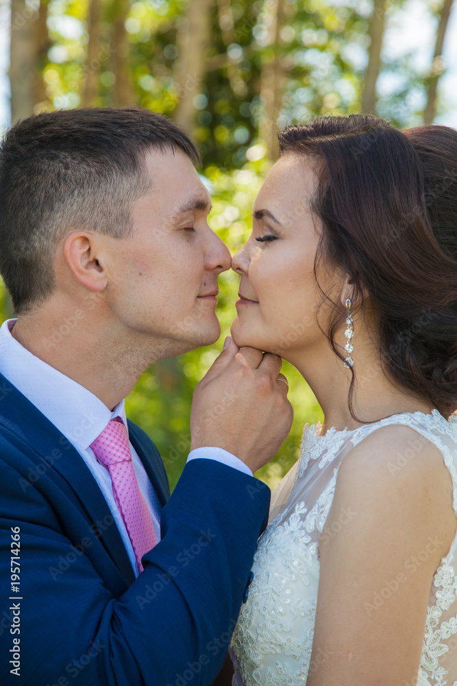 Beautiful happy newlyweds on walk. Summer wedding. Emotions and tenderness of the bride Beautiful happy newlyweds on walk. Summer wedding. Emotions and tenderness of the bride