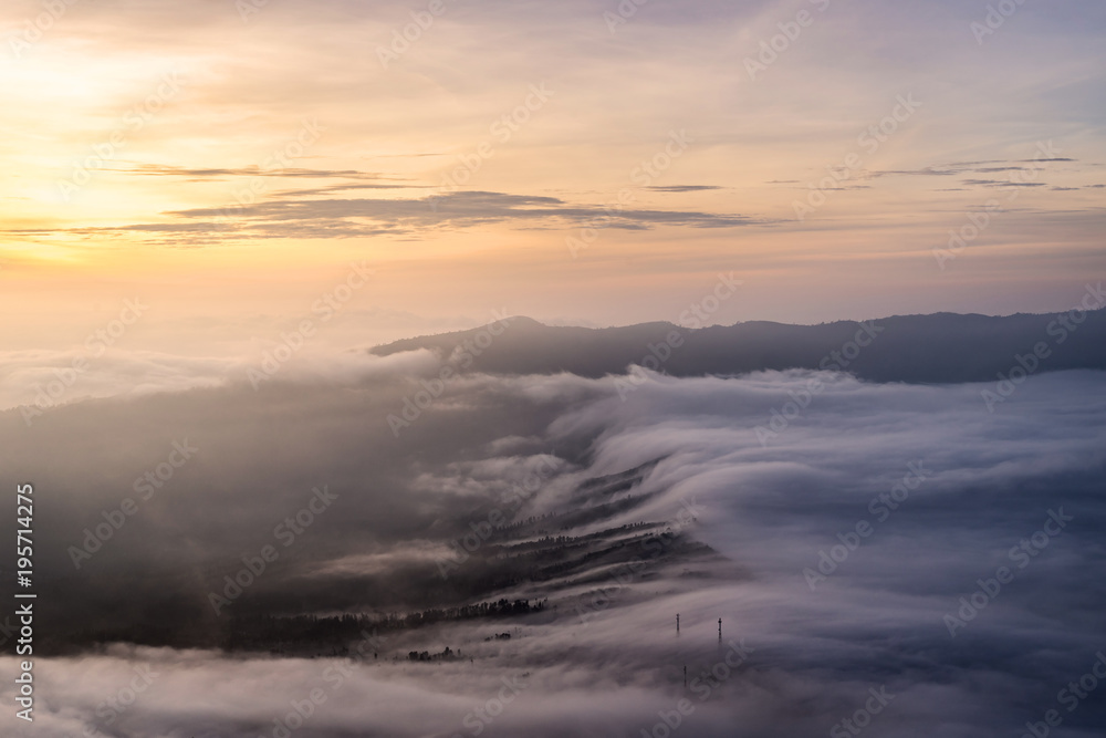 Naklejka premium The sea of mist cover Cemoro Lawang village during sunrise