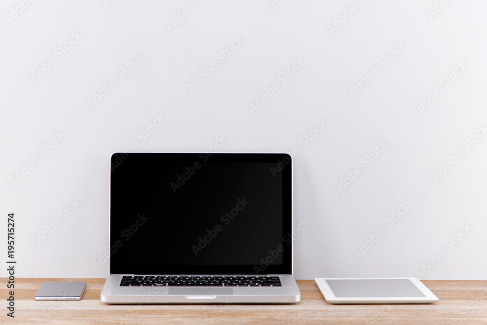 Creative web design agency presentation on multiple devices. Computer display, laptop, tablet, smart phone on white wooden desk. Brick white wall in background. Creative web design agency presentation on multiple devices. Computer display, laptop, tablet, smart phone on white wooden desk. Brick white wall in background.