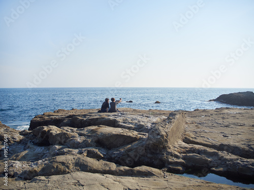 海岸で記念撮影するカップル