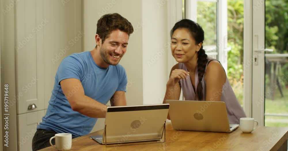 4K Attractive couple working on laptops at home & chatting. Slow motion. 4K Attractive couple working on laptops at home & chatting. Slow motion.