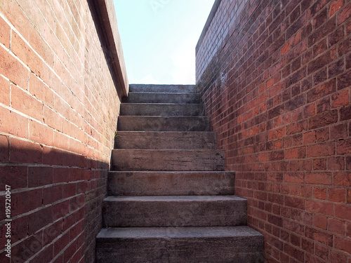 Red brick stone staircase steps into daylight
