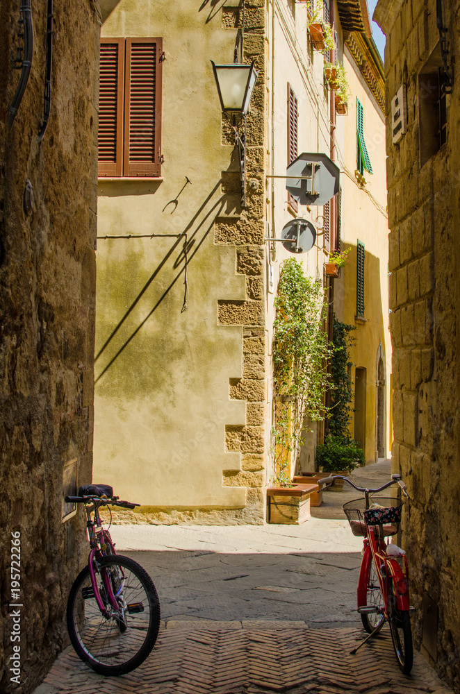 Old street in Pienza with two bicycles; Italy