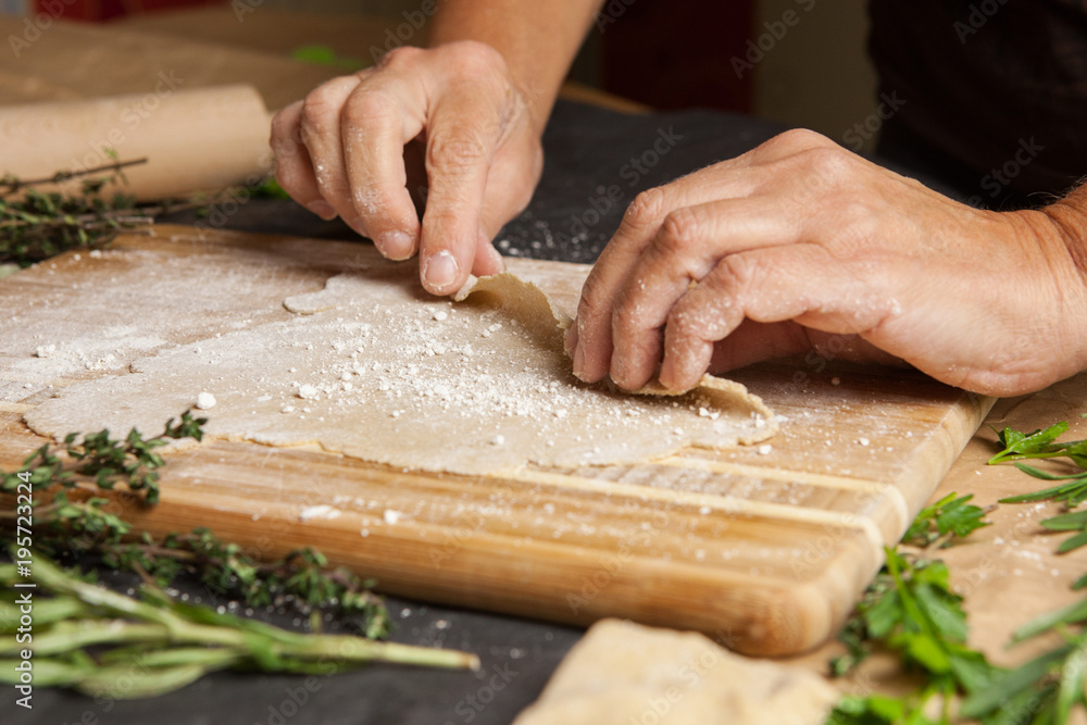 Woman's hands rolling up dough.