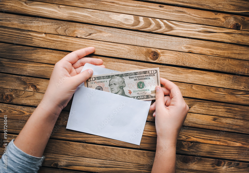 A money note in a white envelope. A person takes out dollars from an envelope. A money note in a white envelope. A person takes out dollars from an envelope.