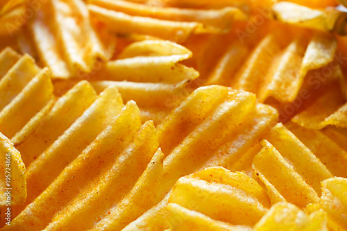 Golden potato chips shot close up on a white background