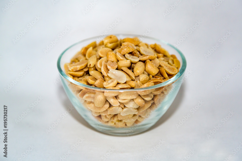 Peeled roasted peanuts with salt in a large glass bowl on a white background
Peeled roasted peanuts with salt in a large glass bowl on a white background