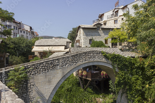 Kriva Cuprija ancient bridge in Mostar, surrounded by city old buildings