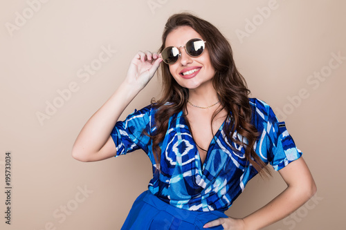 Happy young woman in sunglasses looking excited look at the camera on color studio background. Body language