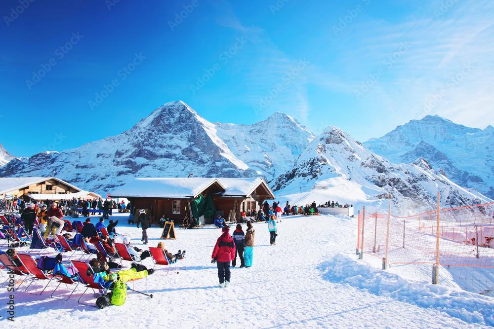 Mannlichen mountain and resort with tourists at winter Swiss Alps