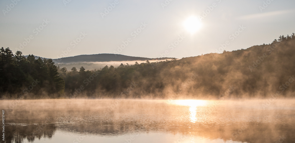 Gorgeous sunrise over pond with mountain views panorama