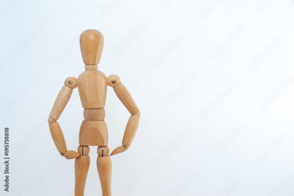 A wooden dummy stands in a confident pose. On a white background. A wooden dummy stands in a confident pose. On a white background.