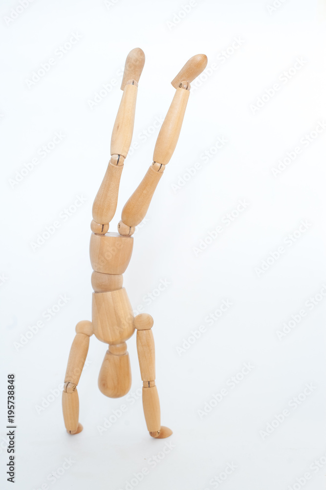 A wooden manicure performs exercises of gymnastics. On a white background. A wooden manicure performs exercises of gymnastics. On a white background.