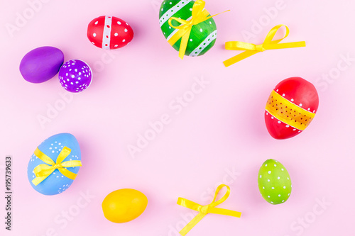 Colorful easter eggs on pink pastel background flat lay. Copy space