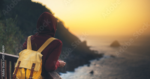 Hipster hiker tourist with backpack looking of seascape sunset on background sea, girl enjoying ocean horizon, panoramic sunrise, traveler relax holiday concept, sunlight view in trip vacation