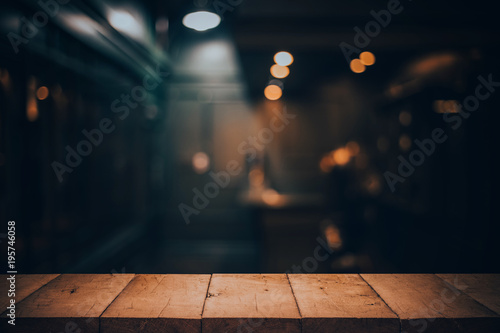 Wood table top on blurred of counter cafe shop with light bulb.Background for montage product display or design key visual