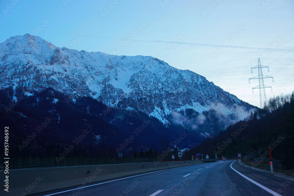 Road with view on Alpine mountains in Austria evening