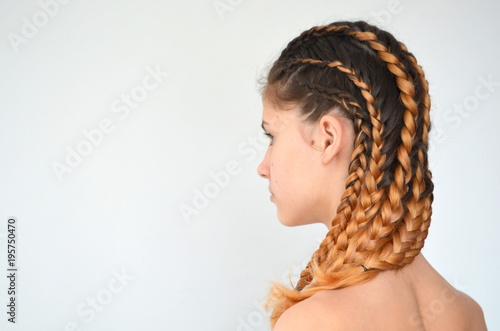 Девочка-подросток с современными косами с канекалоном натуральных цветов 