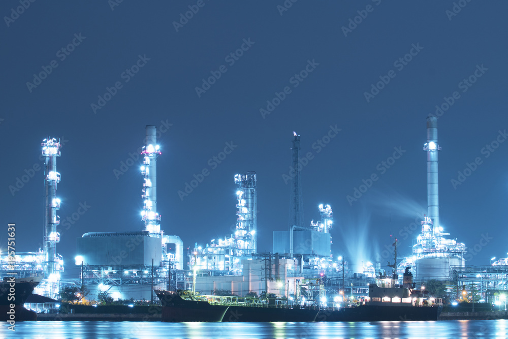 Oil refinery with Chemical tanker ship is alongside at dusk.