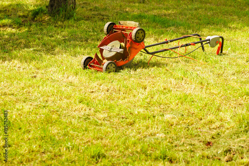 Broken old lawnmower in backyard grass