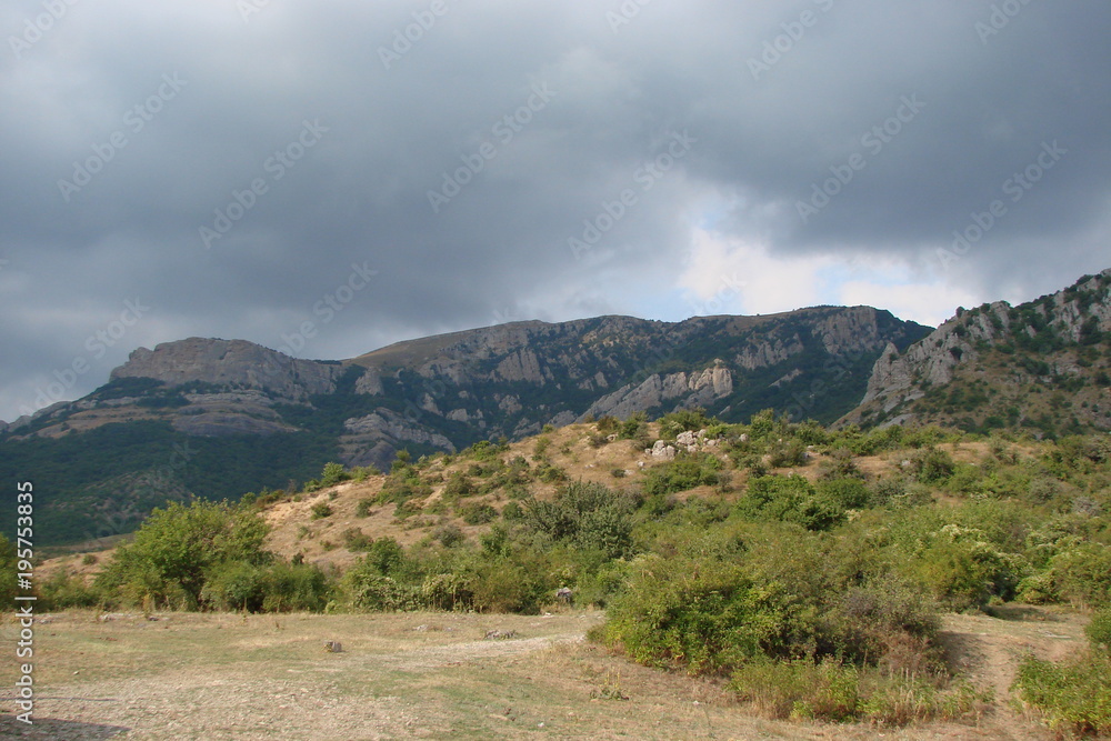 Crimean rocks against the background of cloudy rainy sky.