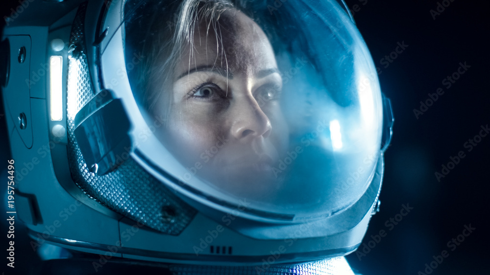 Portrait Shot of the Courageous Female Astronaut  Wearing Helmet in Space, Looking around in Wonder. Space Travel, Exploration and Solar System Colonization Concept.