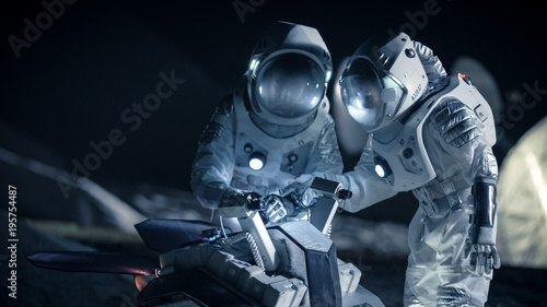 Obraz na płótnie Two Astronauts in Space Suits on an Alien Planet Prepare Space Rover for Planet's Surface Exploration Expedition