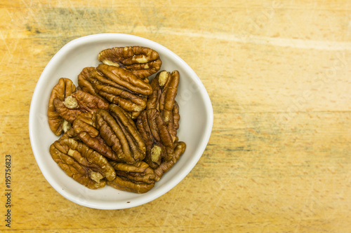Bowl with shelled pecan nuts. View from above.