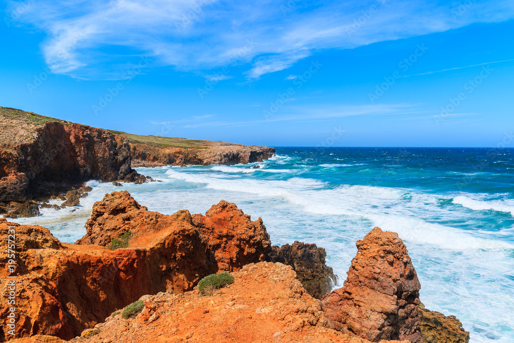Rocks and sea with waves near Praia da Bordeira beach, popular place to do kite surfing, Algarve, Portugal
