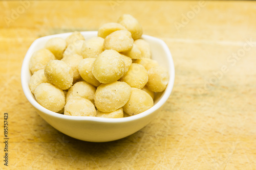 Bowl with roasted and salted macadamia nuts.