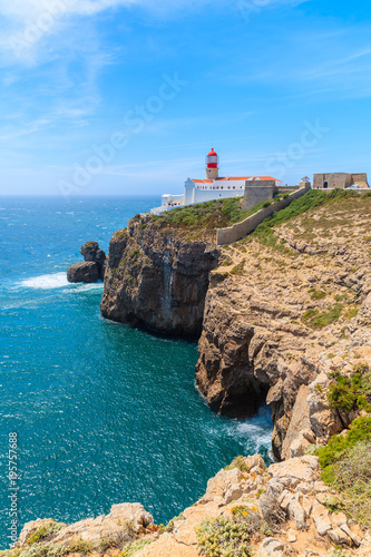 Blue sea and lighthouse on top of cliff at Cabo Sao Vicente, Algarve region, Portugal